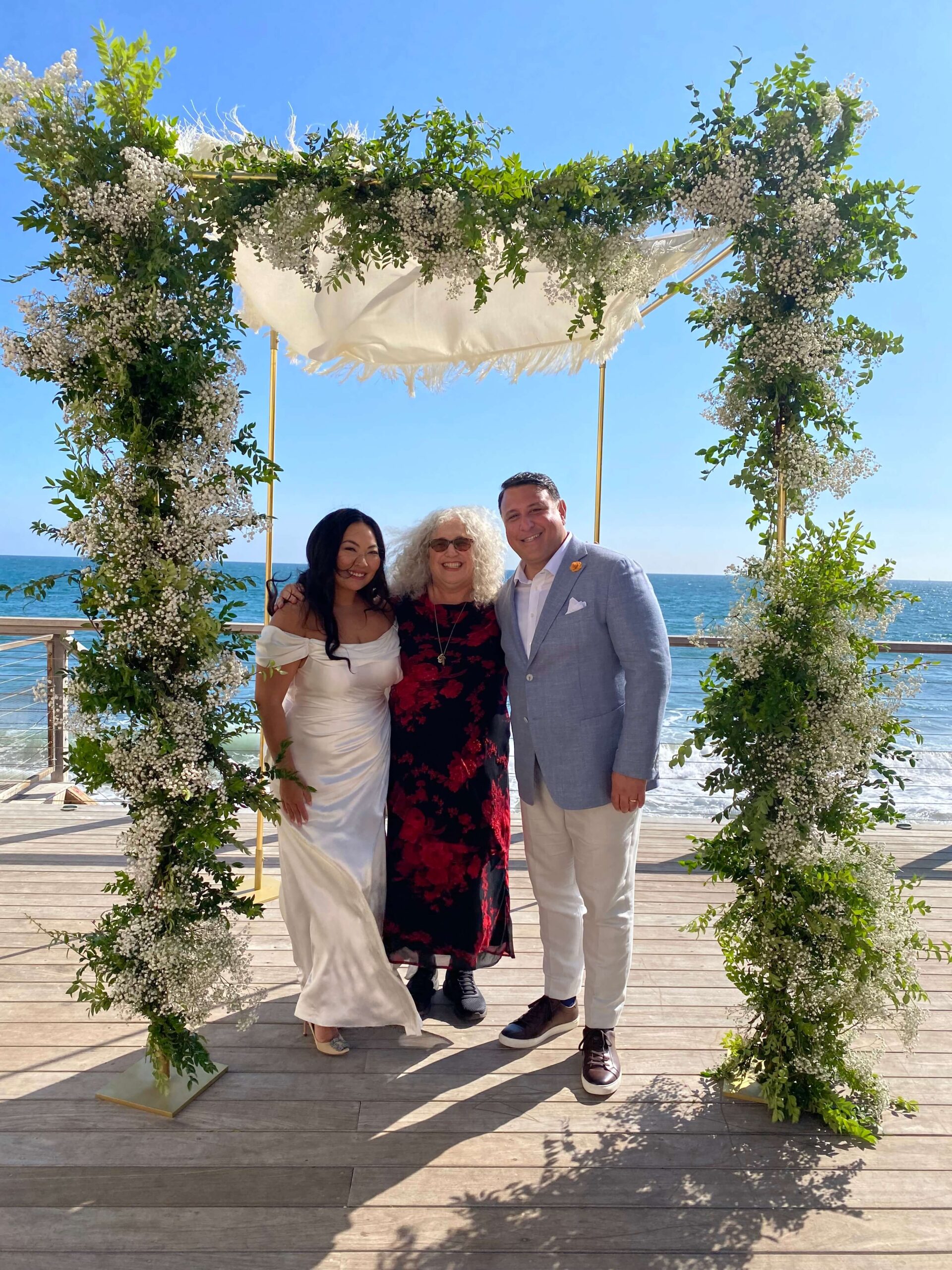 Mitzi Schwarz with couple during beach wedding ceremony