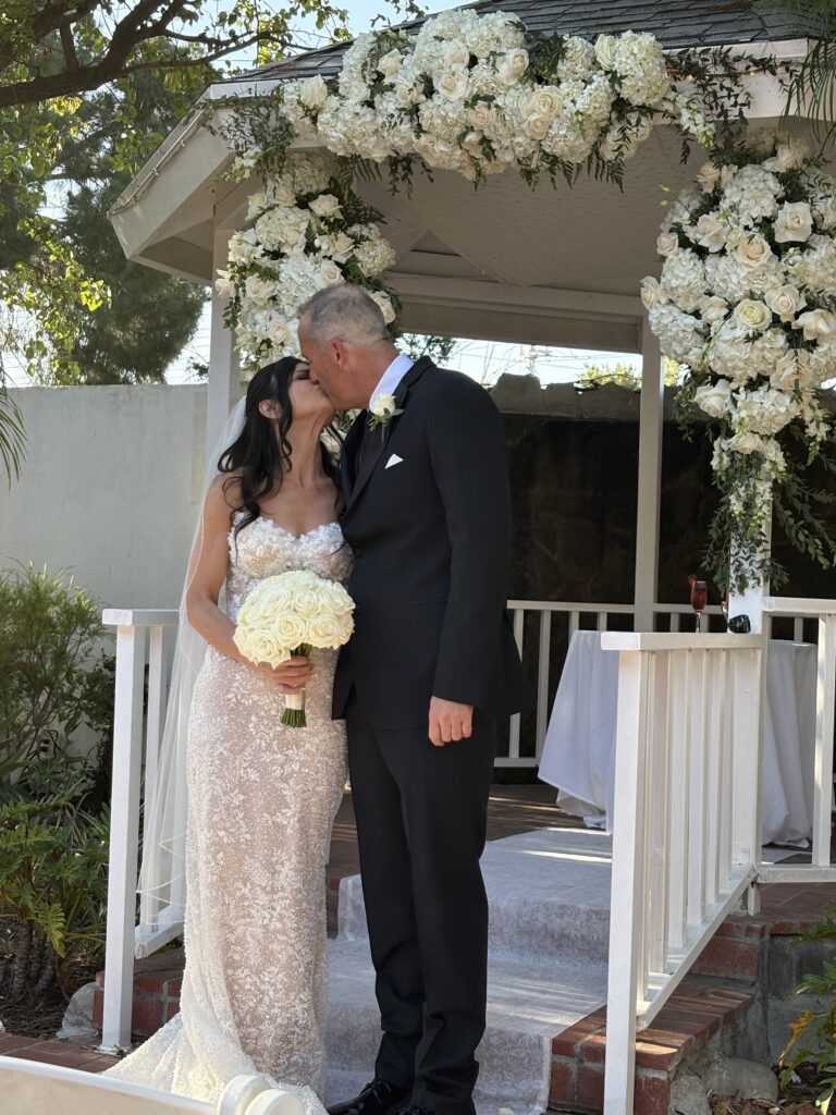 A couple under their wedding canopy giving each other a kiss